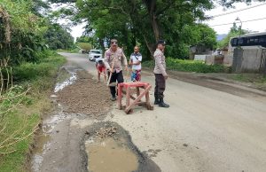 Polsek Maluk Bantu Warga Timbun Jalan Berlubang